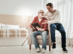 senior and caregiver reading book