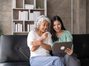 caregiver and senior doing video call on laptop